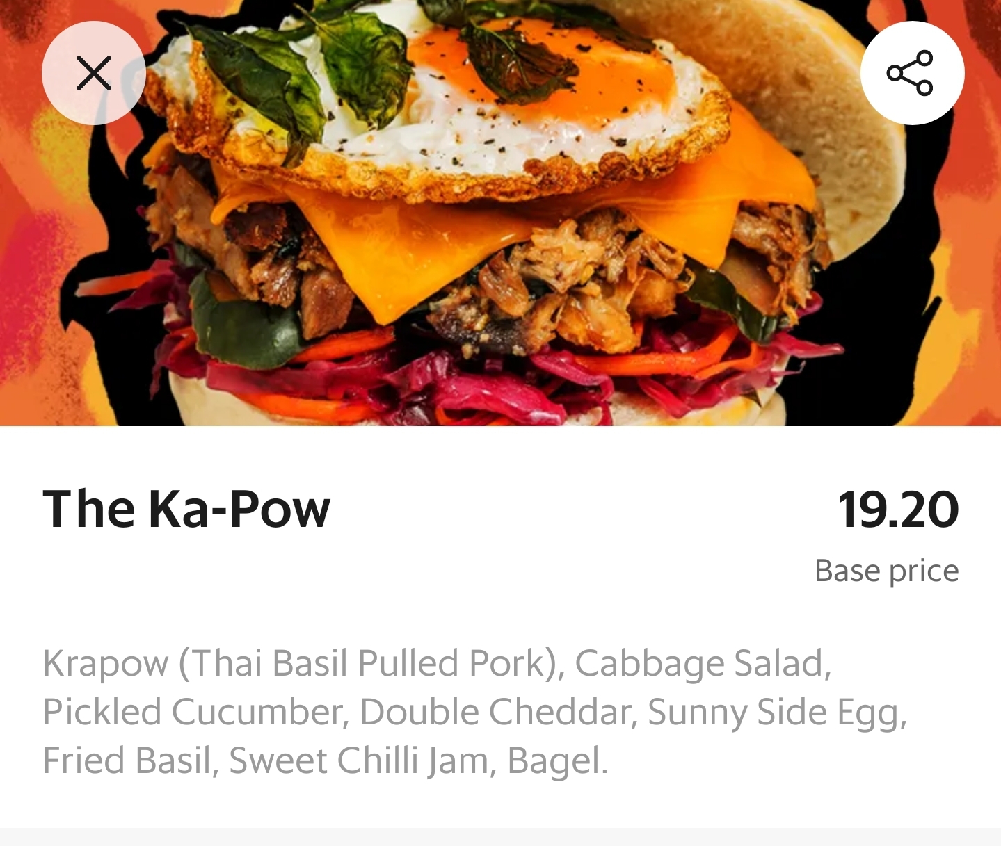 The Ka-Pow bagel from a food delivery app—a gourmet bagel filled with Thai basil pulled pork (krapow), double cheddar cheese, sunny side up egg, cabbage salad, pickled cucumber, sweet chili jam, and fried basil, photographed from above